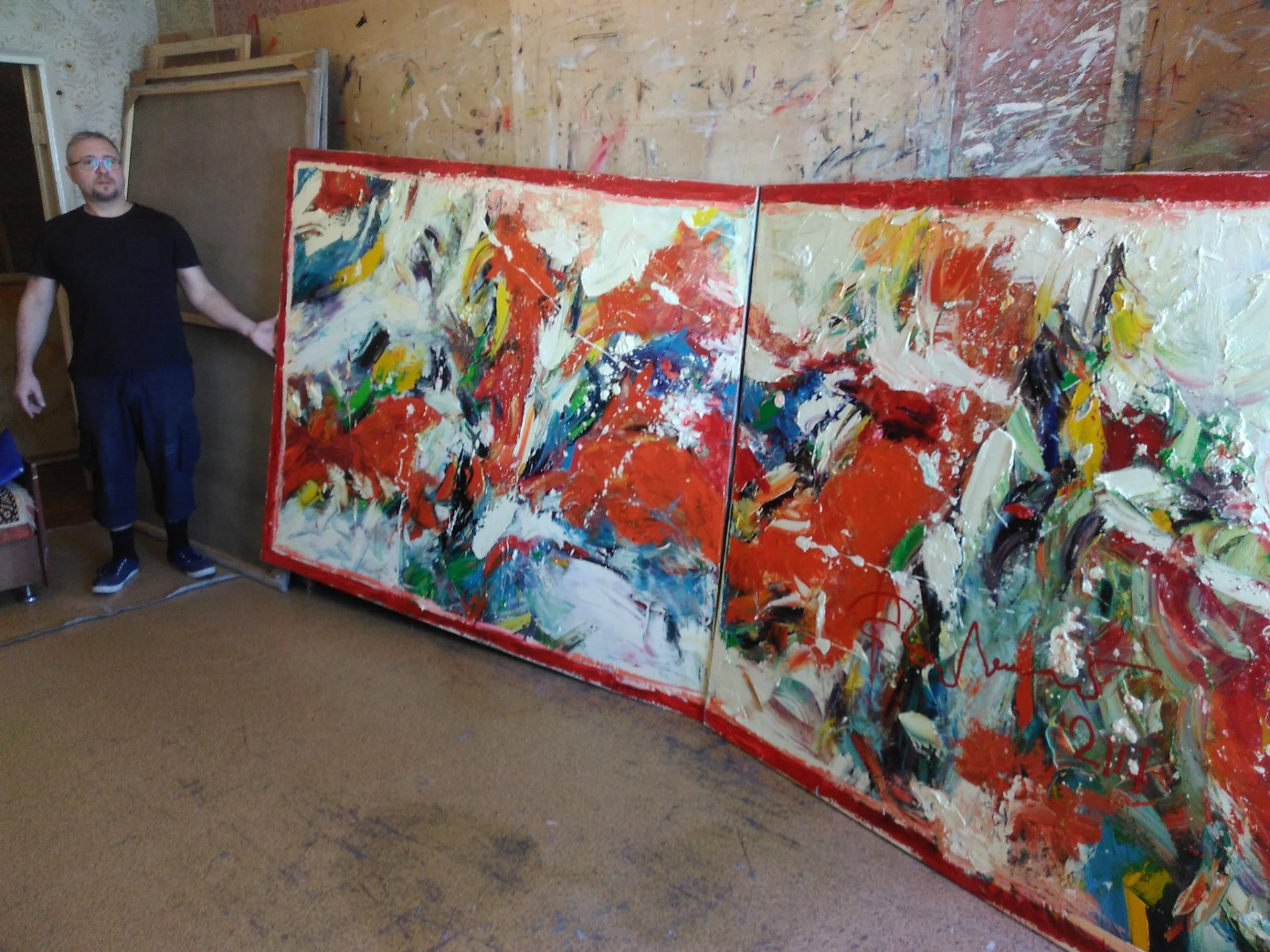 The artist beside a large-format diptych in the studio